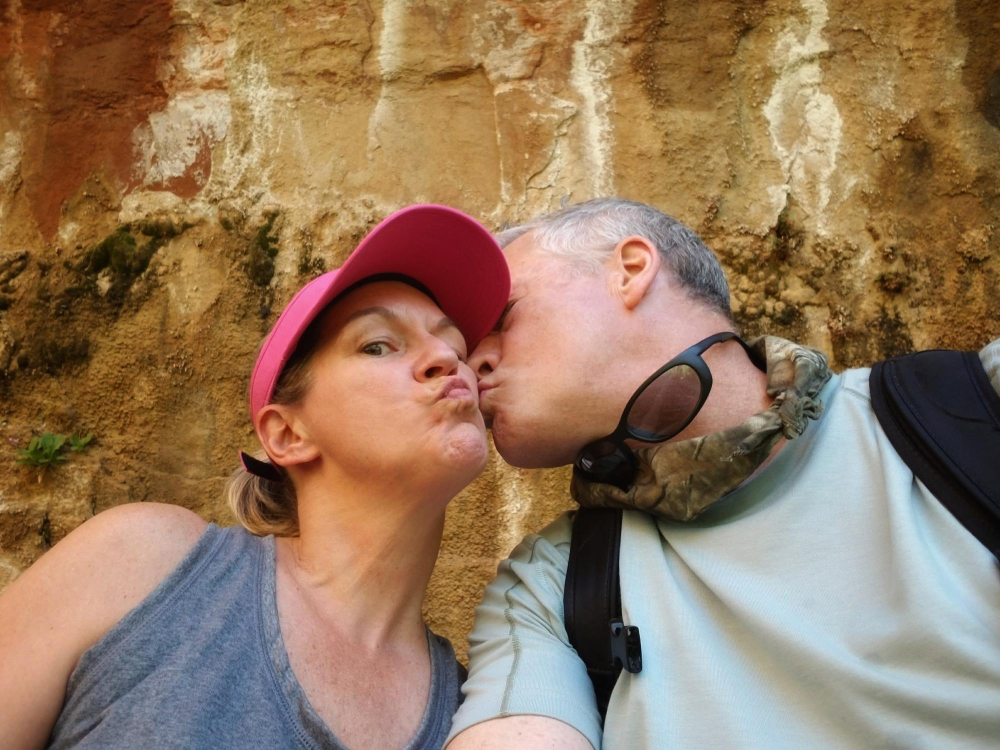 Un uomo dà un bacio sulla guancia alla compagna durante una passeggiata